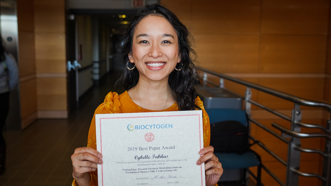 Fourth-year Ph.D. student Cybelle Tabilas holding an award received for excellent research
