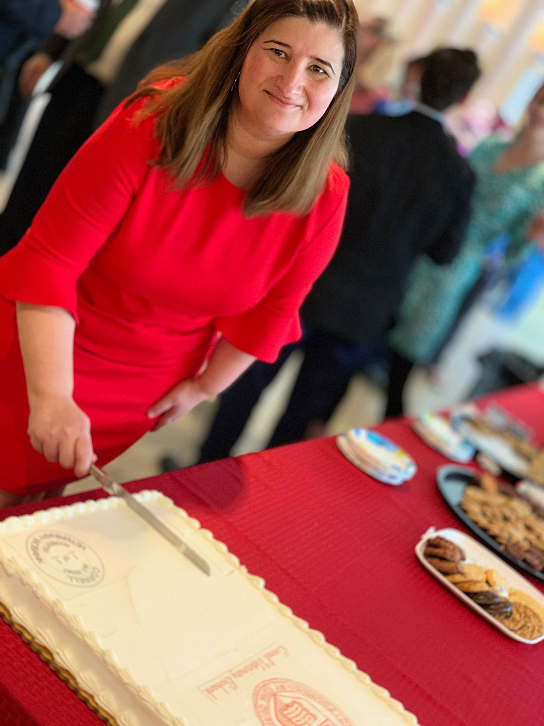 Dr. Marta Castelhano cuts the "accredited" cake at the event.