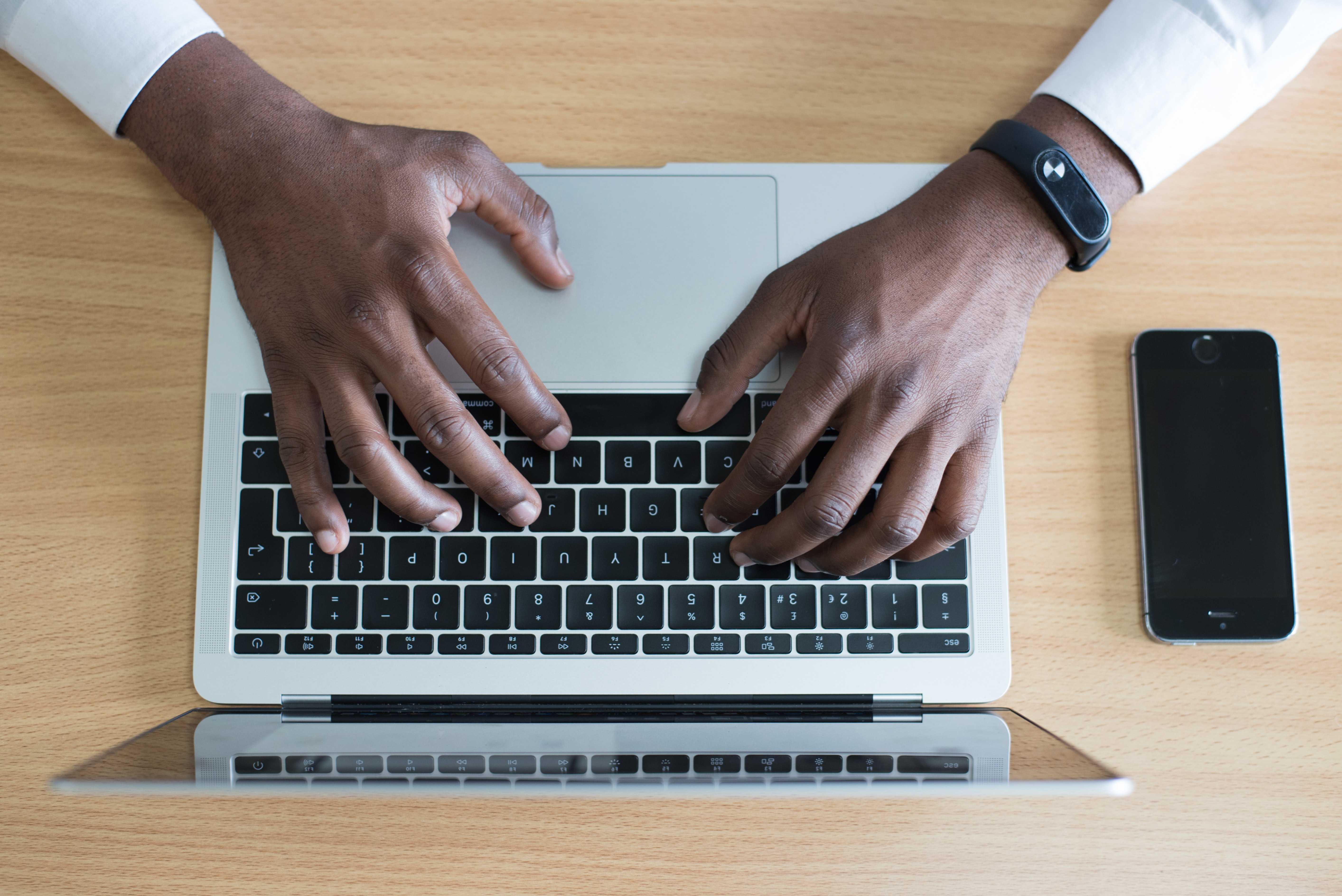 Black person's hands using a laptop