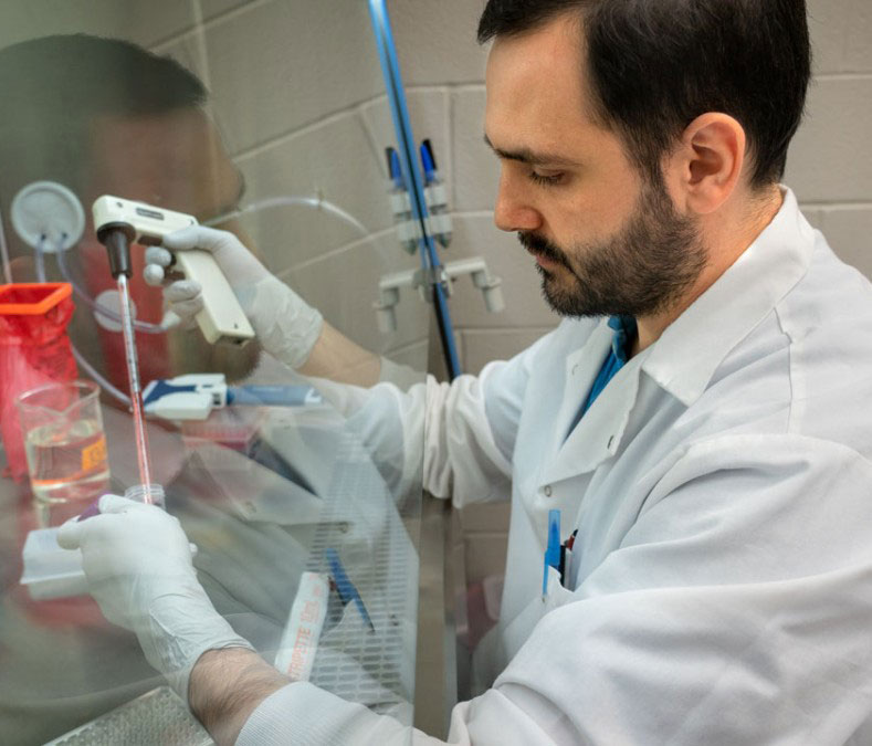 Graduate student Esteban Flores isolates cells while working on antiviral solutions to COVID-19