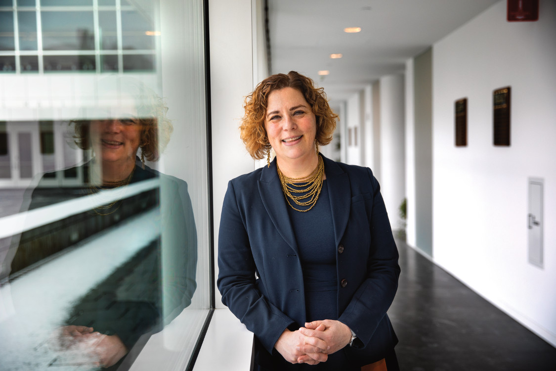 Paula Cohen in a business jacket smiling at the camera in an office setting