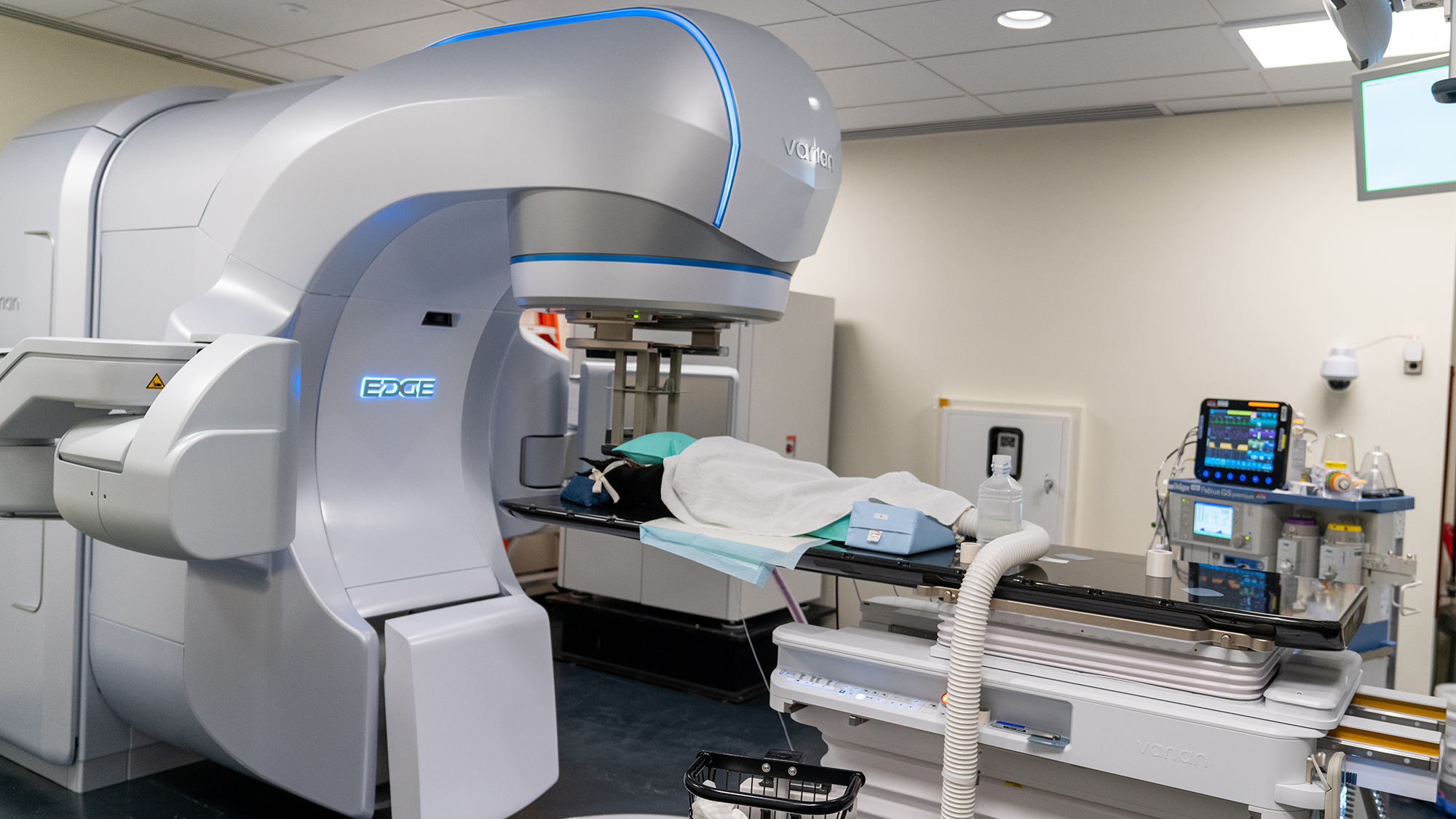 A patient on the bench beneath the linear accelerator