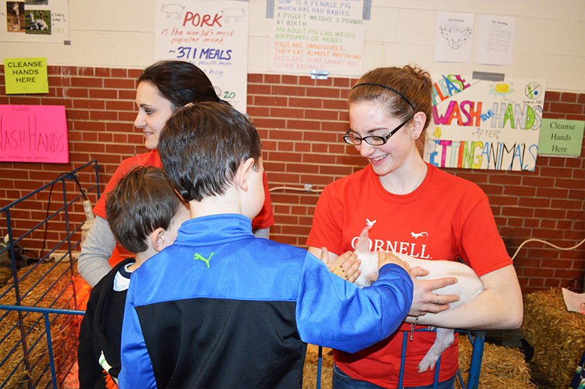 Student holding a lamb at Open House