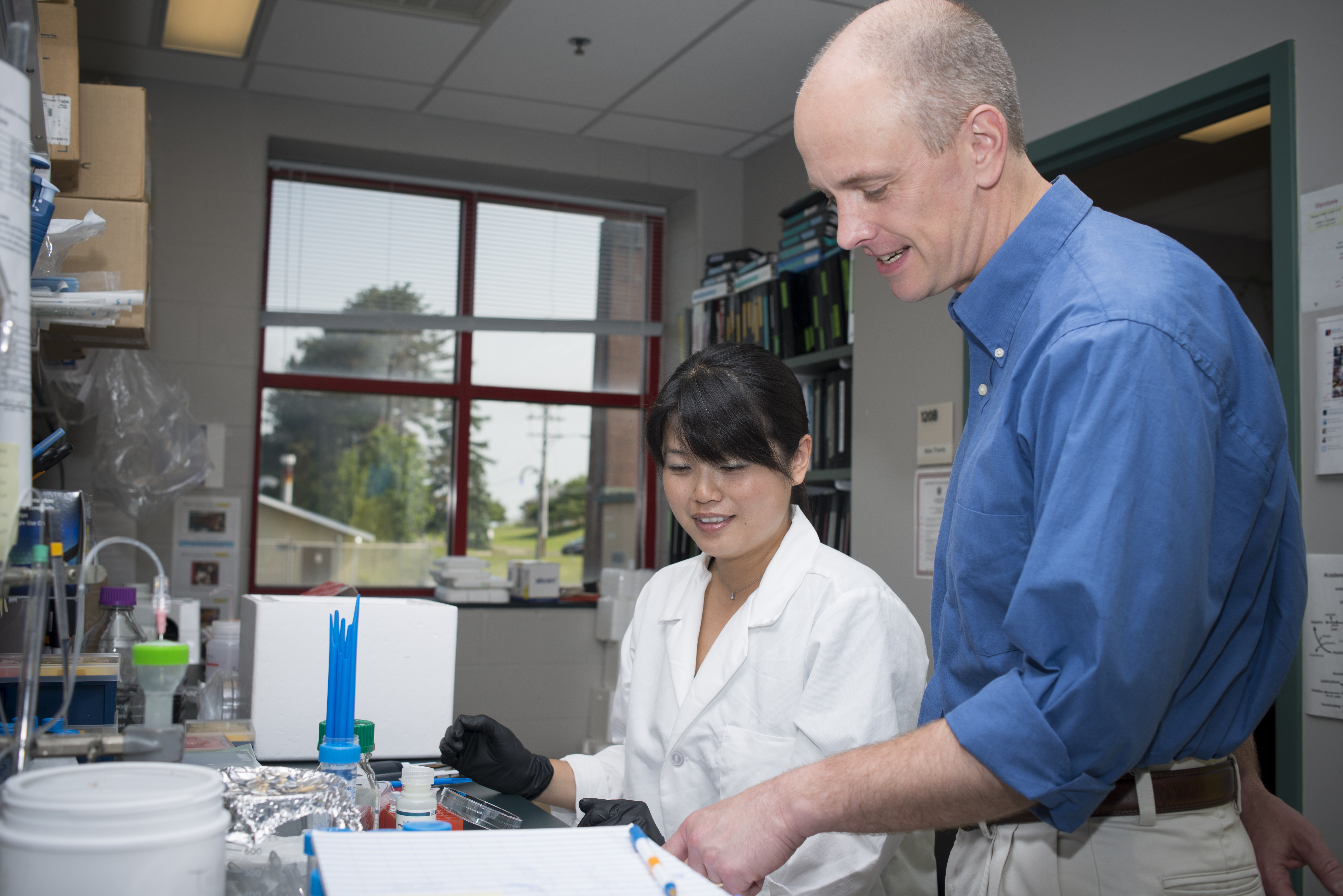 Dr. Travis and postdoctoral associate consulting about benchwork in the lab