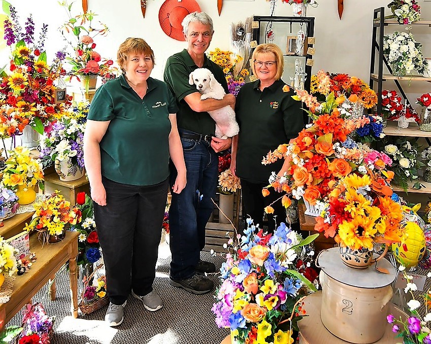 Bella the dog with owners in a florist shop