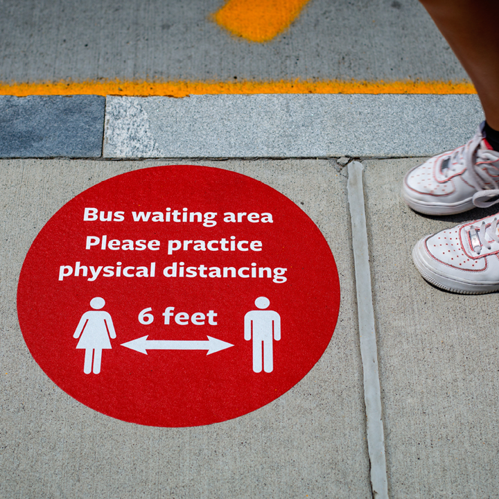 a sign on the sidewalk encouraging social distancing