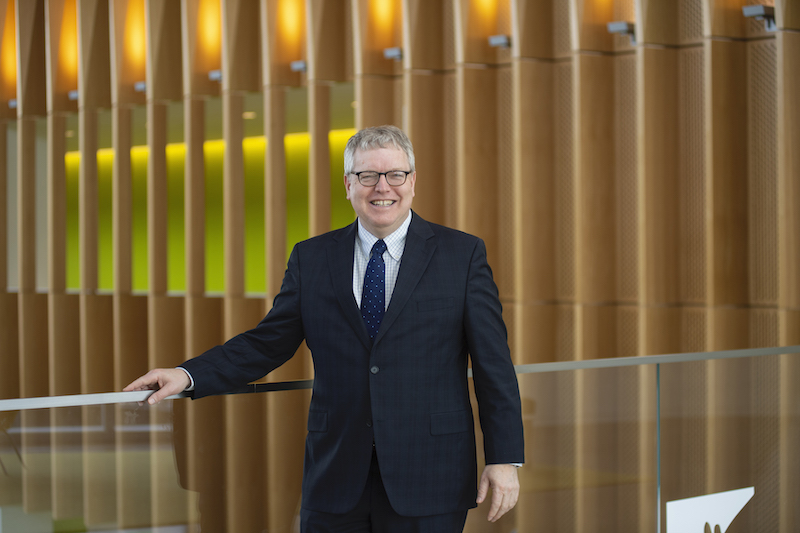 Dean Warnick standing on the second floor atrium overlook of CVM