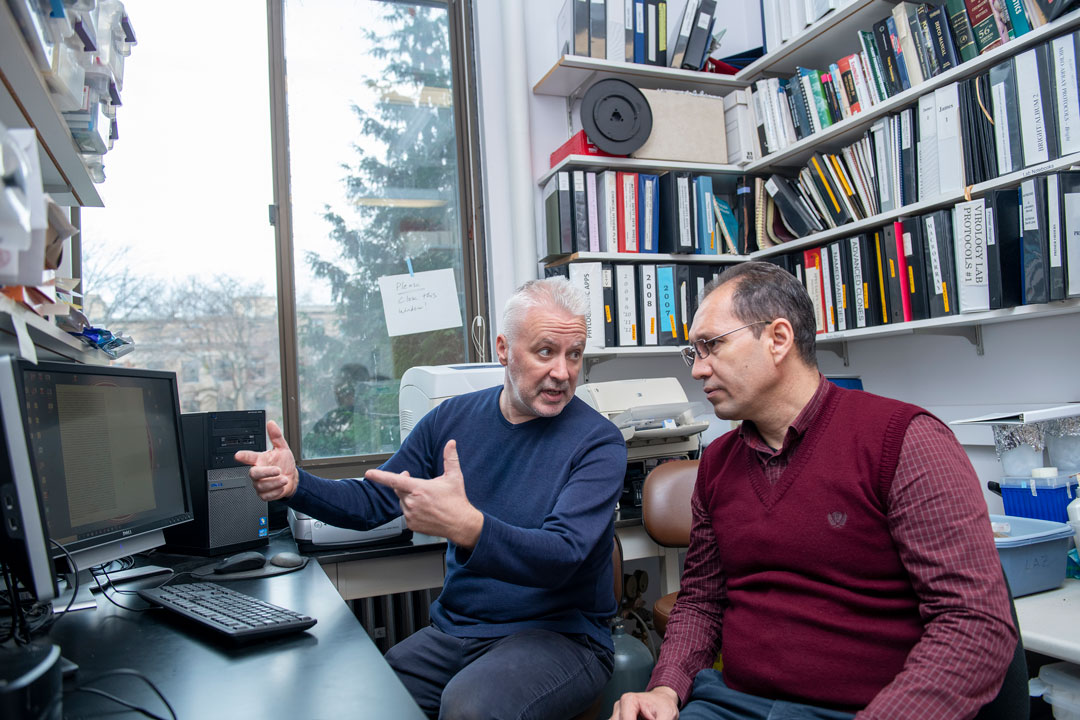Two men in a faculty office examining a computer screen