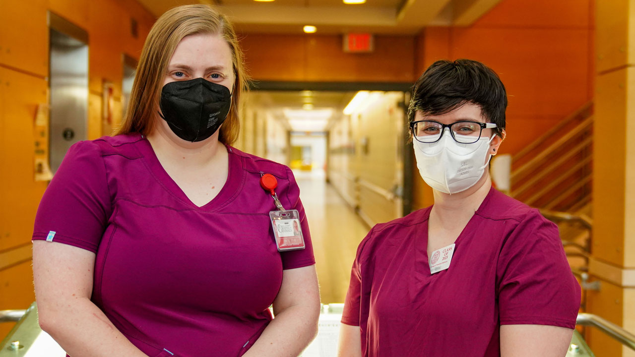 Katie Trail and Anna Young pose in scrubs at the World Spay Day event