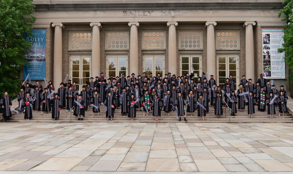 The Cornell Veterinary Class of 2021 poses for a physically-distant class picture outside Bailey Hall, wearing the caps and gowns