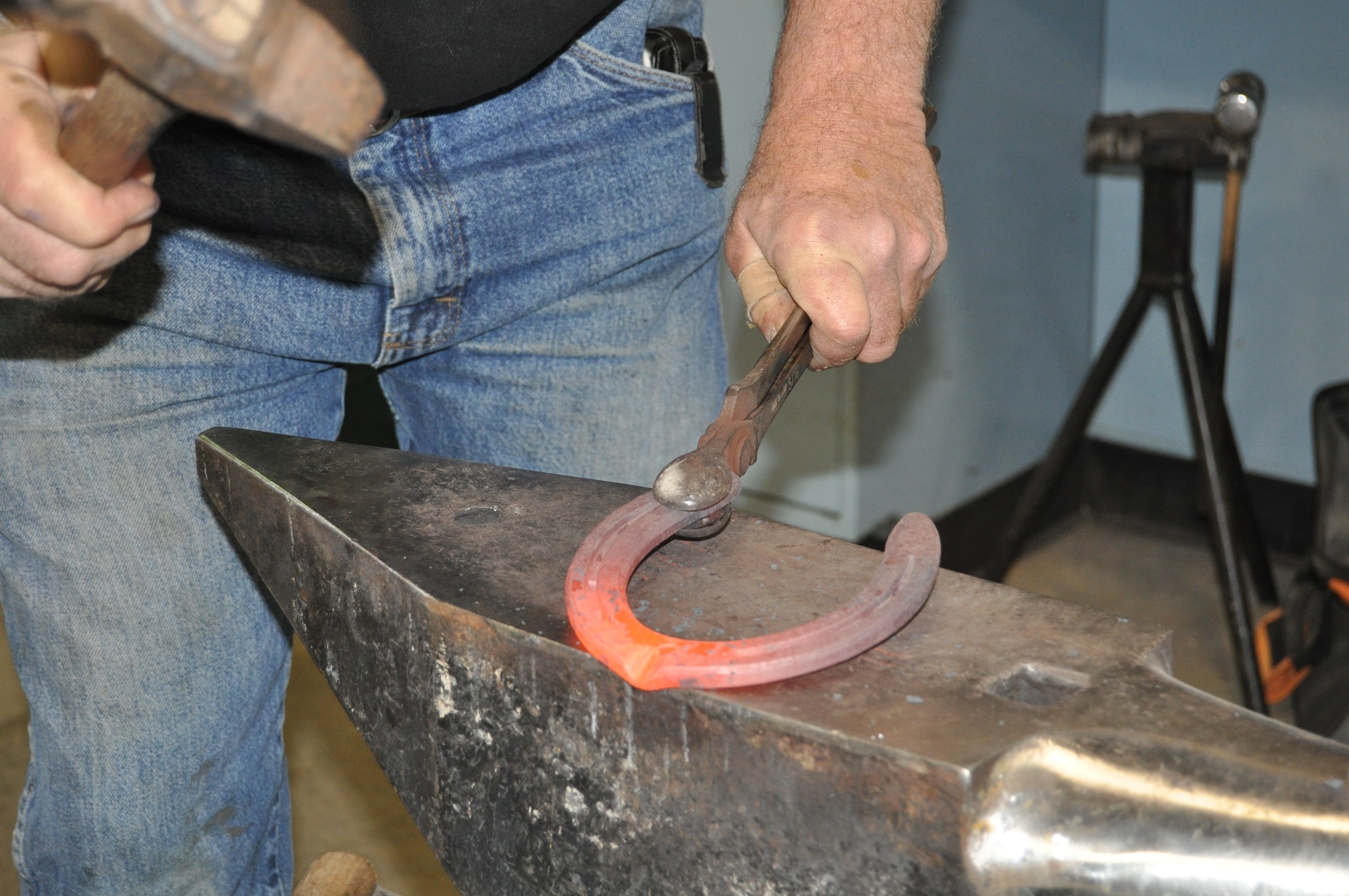 A horseshoe being made over an anvil 