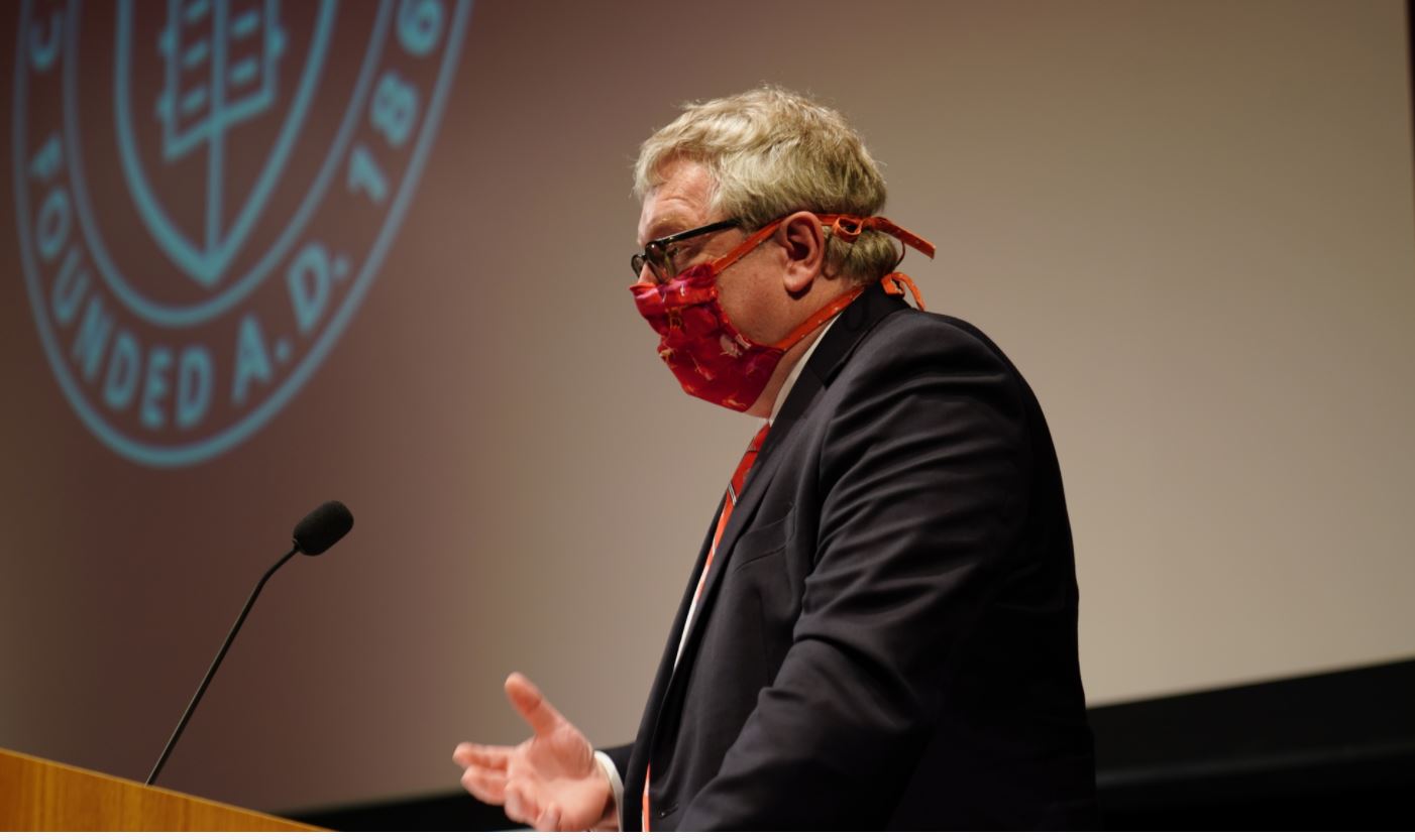 Dean Warnick speaking at an event wearing a mask