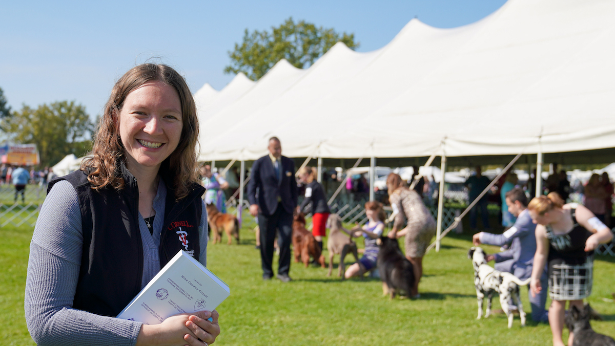 Michelle Greenfield in a Cornell Vet vest stands on the grounds at the dog show