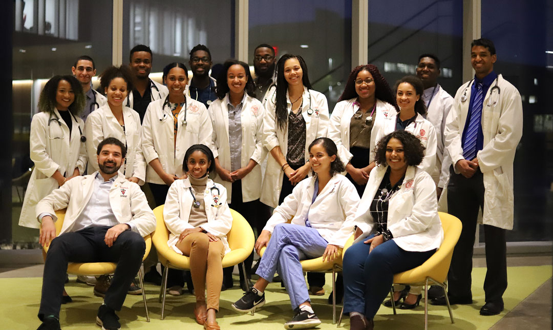 A group veterinary student of color seated and standing in the Cornell Vet atrium to mark Black History Month