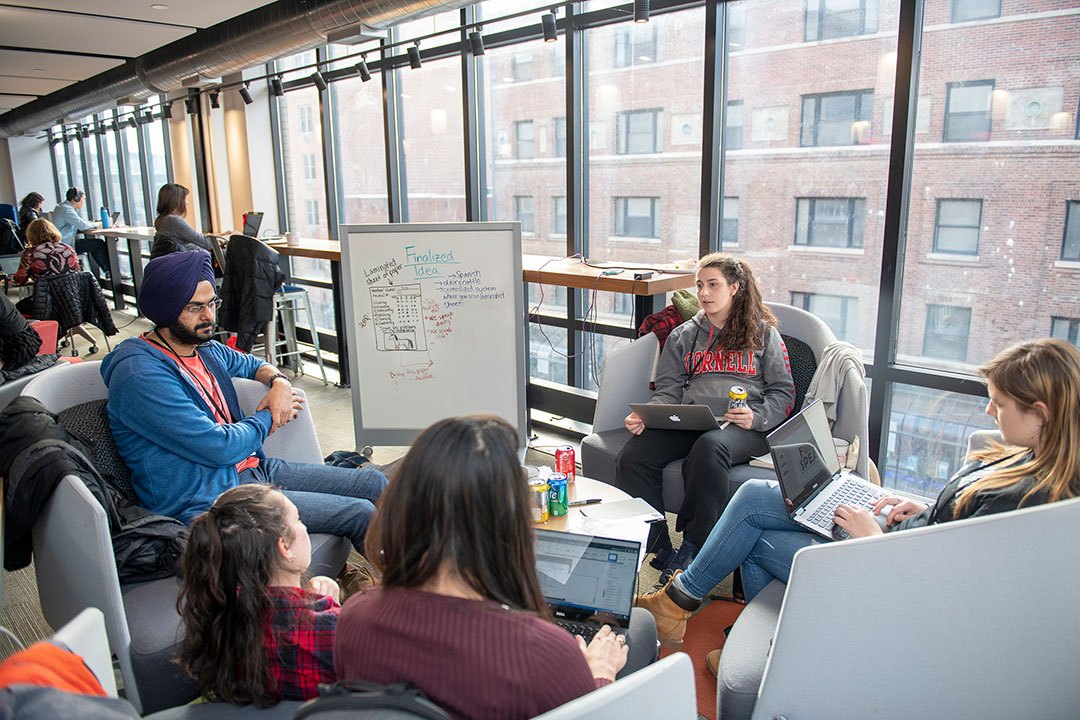 A group of students with a whiteboard at eHub during the hackathon