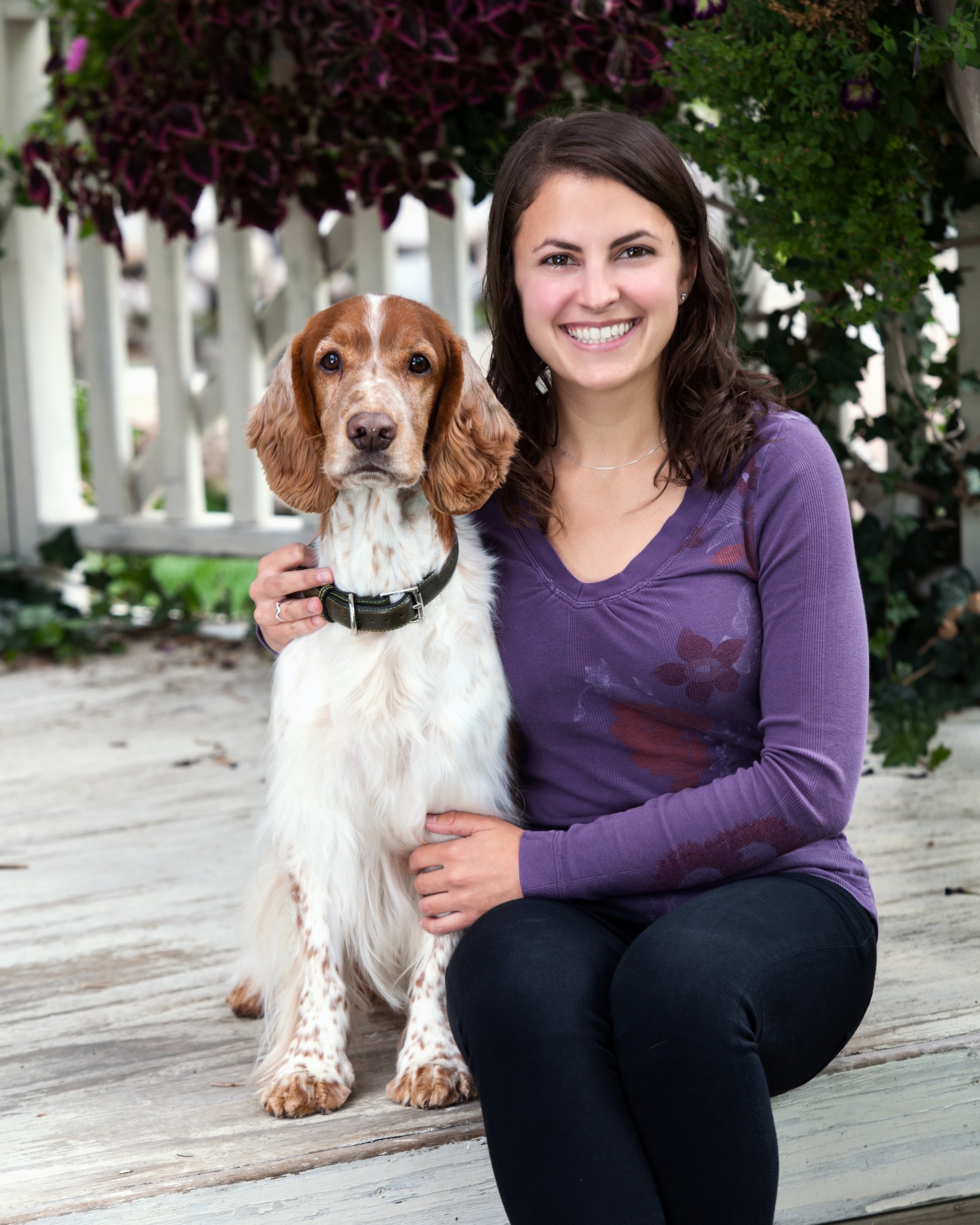 Dr. Jenna Dockweiler kneels next to a Welsh Springer Spaniel