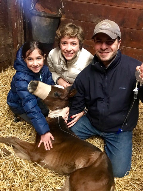 Jorge Colon and his daughters pose next to a foal
