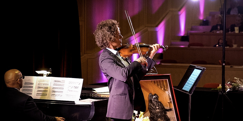 Tim Fain posing with violin and piano