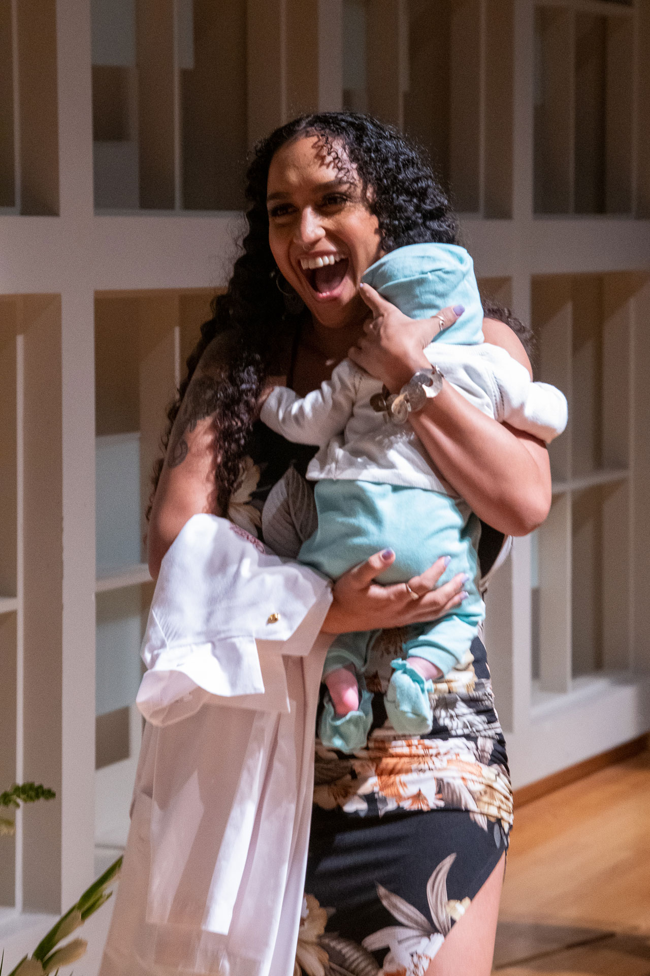 A student carries her baby during the White Coat Ceremony