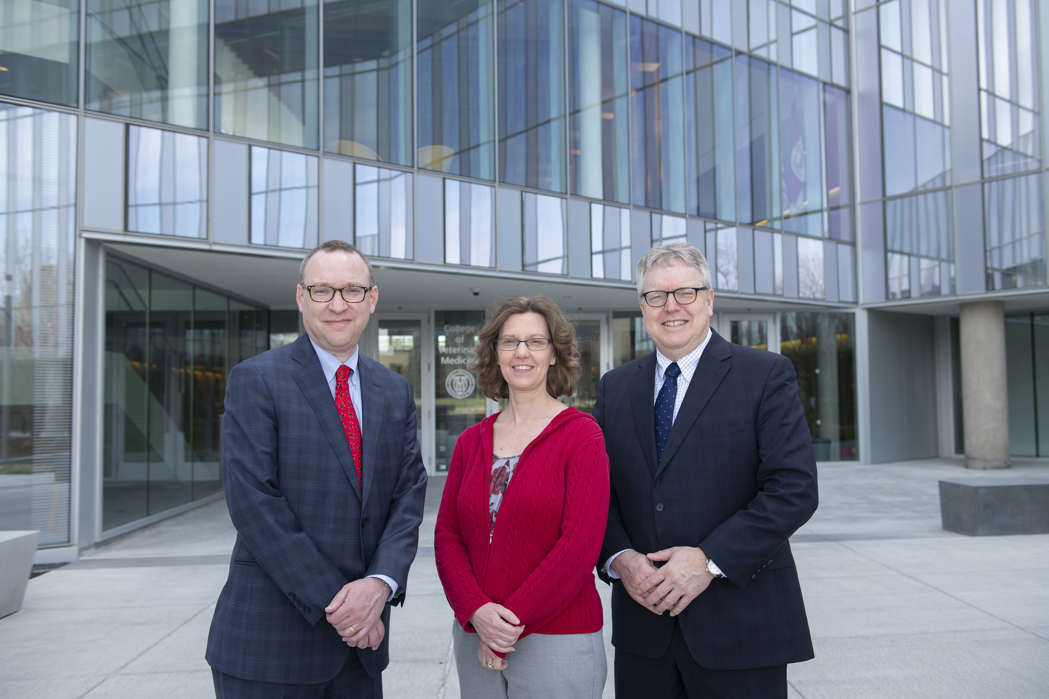 3 vet school administrators posing in front of Sherman Hall