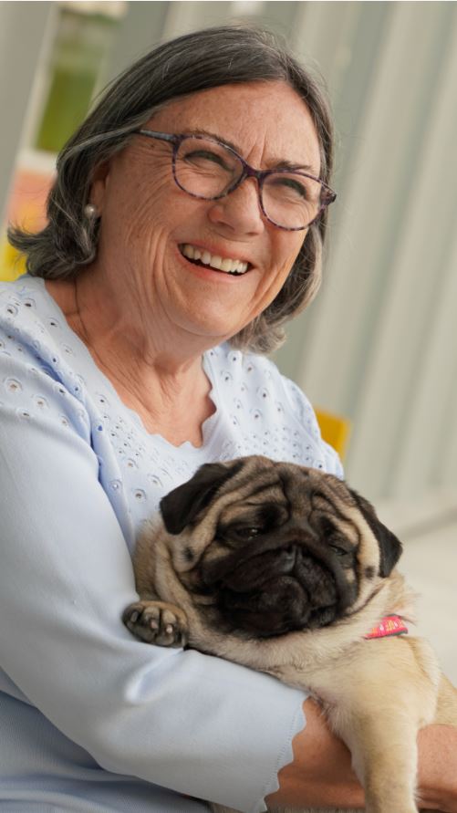 a woman holding a pug