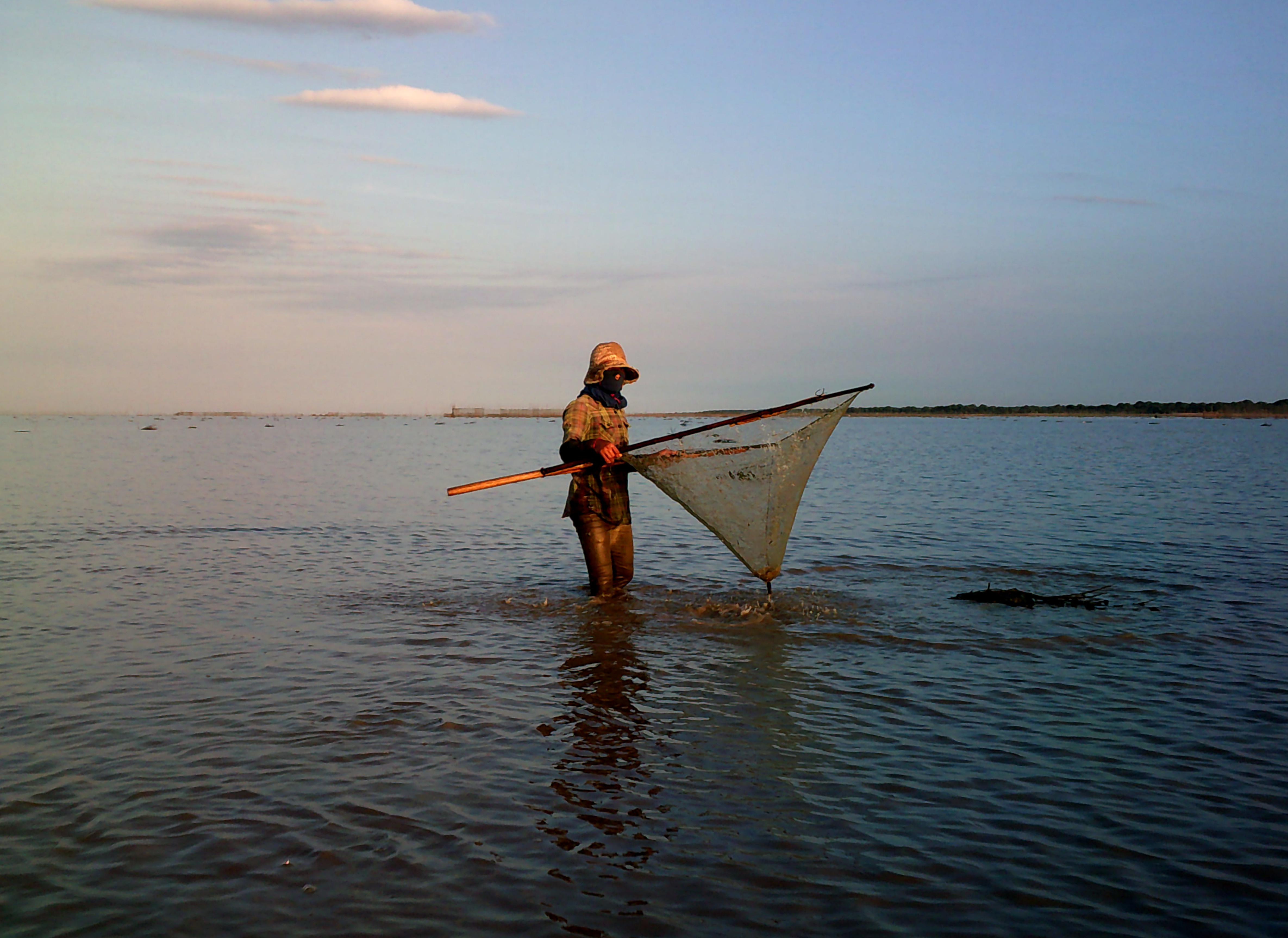 A fisherman checks his catch in Cambodia