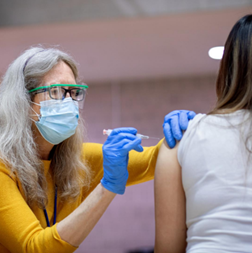 woman with mask giving injection
