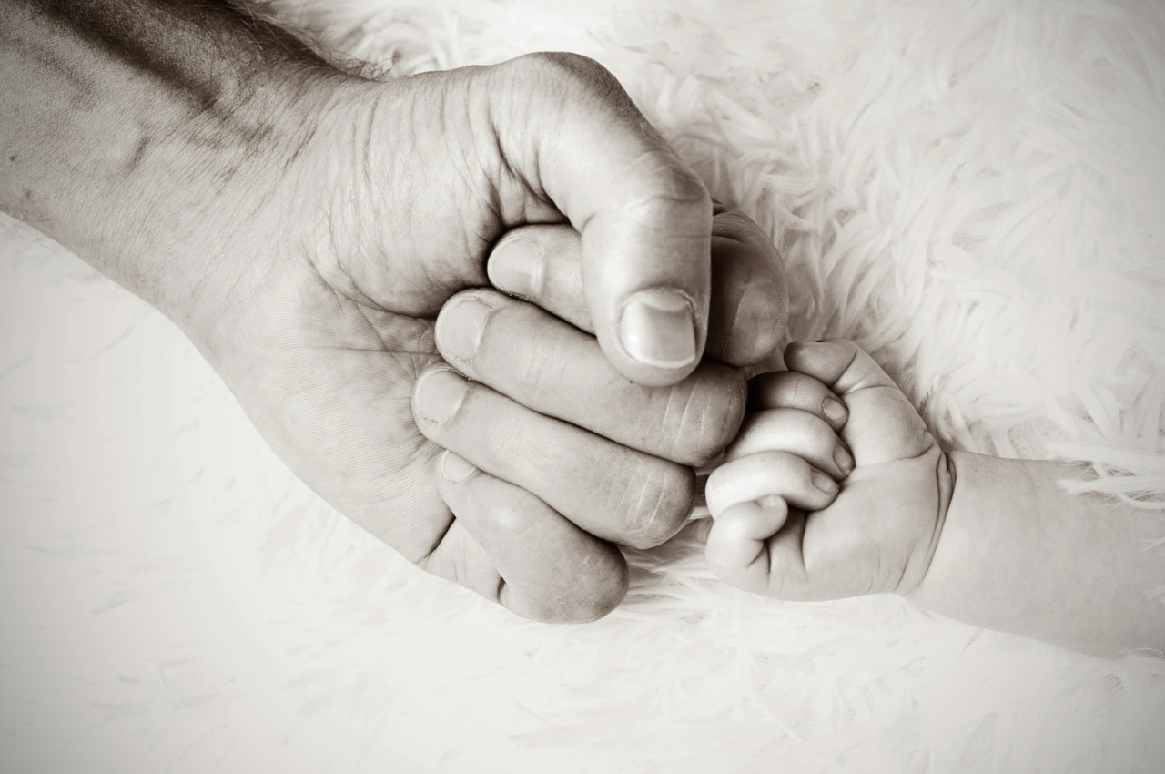 The fists of an adult and a newborn