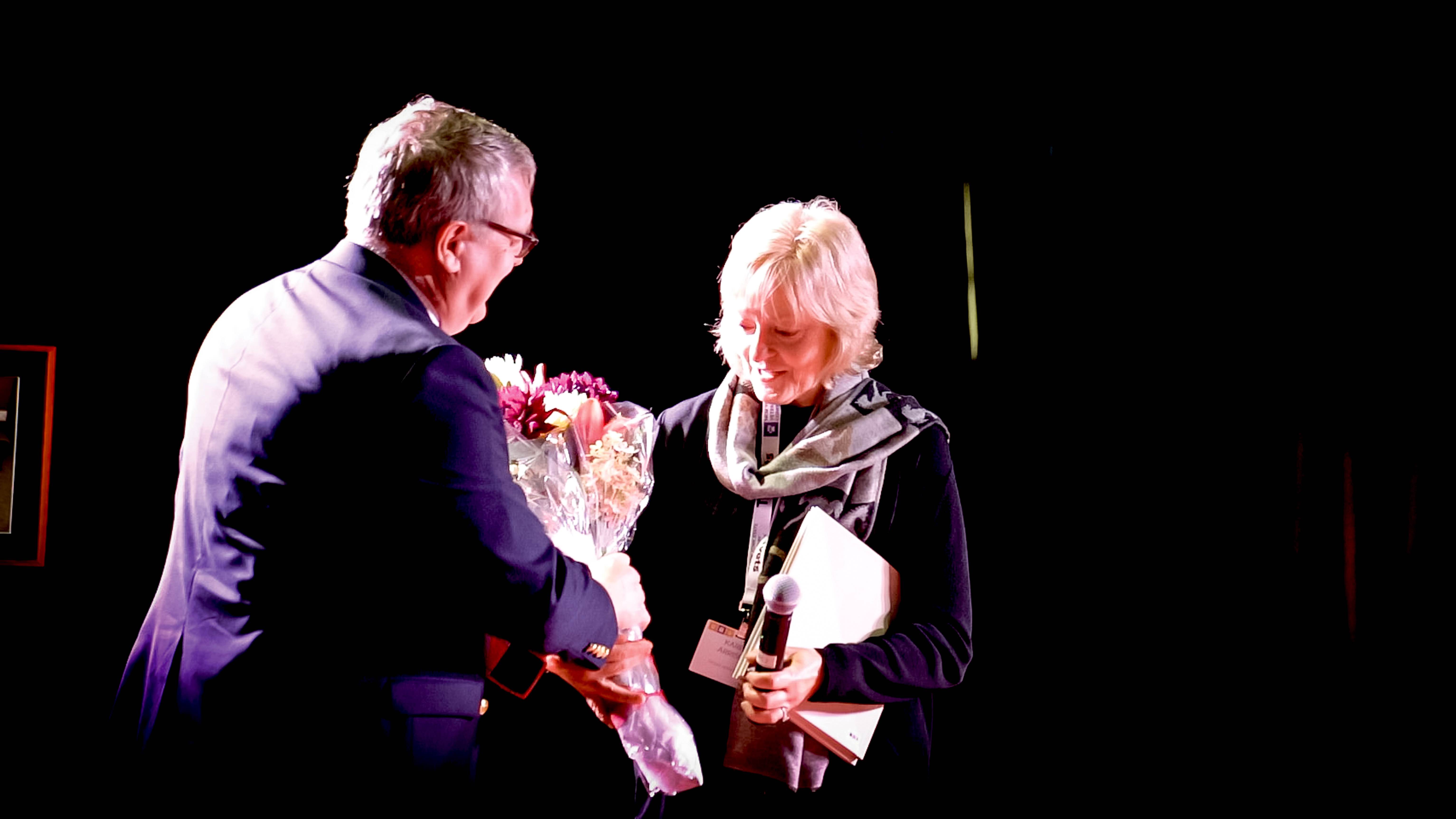 Dean Lorin Warnick presents Karen Arrison with flowers