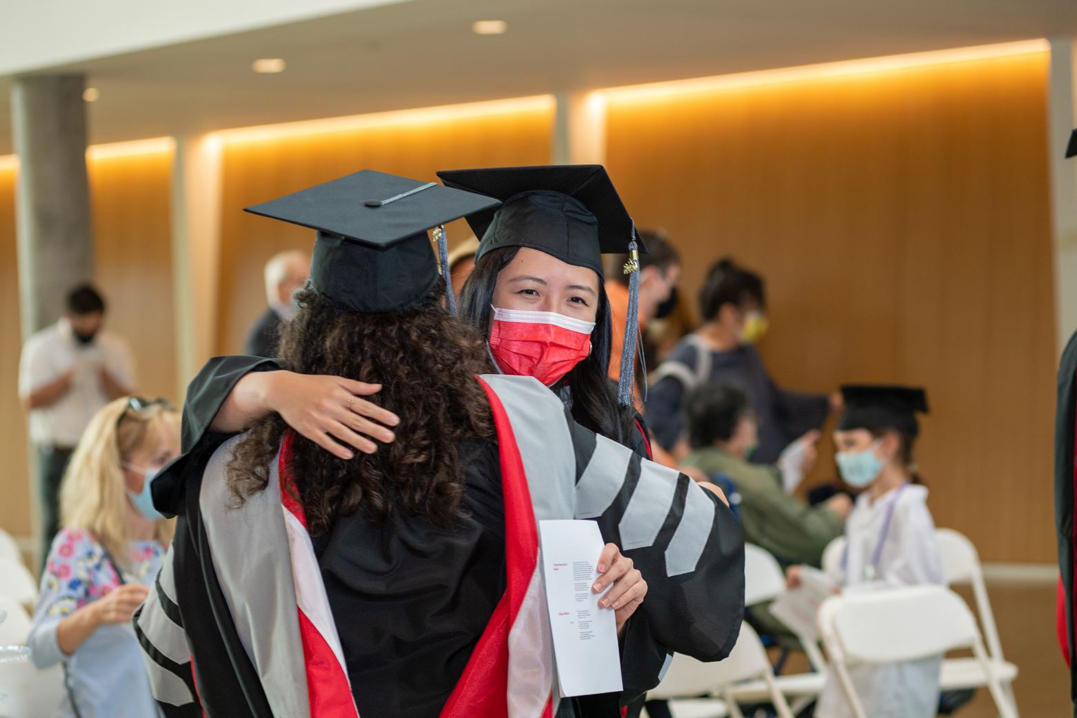 two classmates hug at hooding