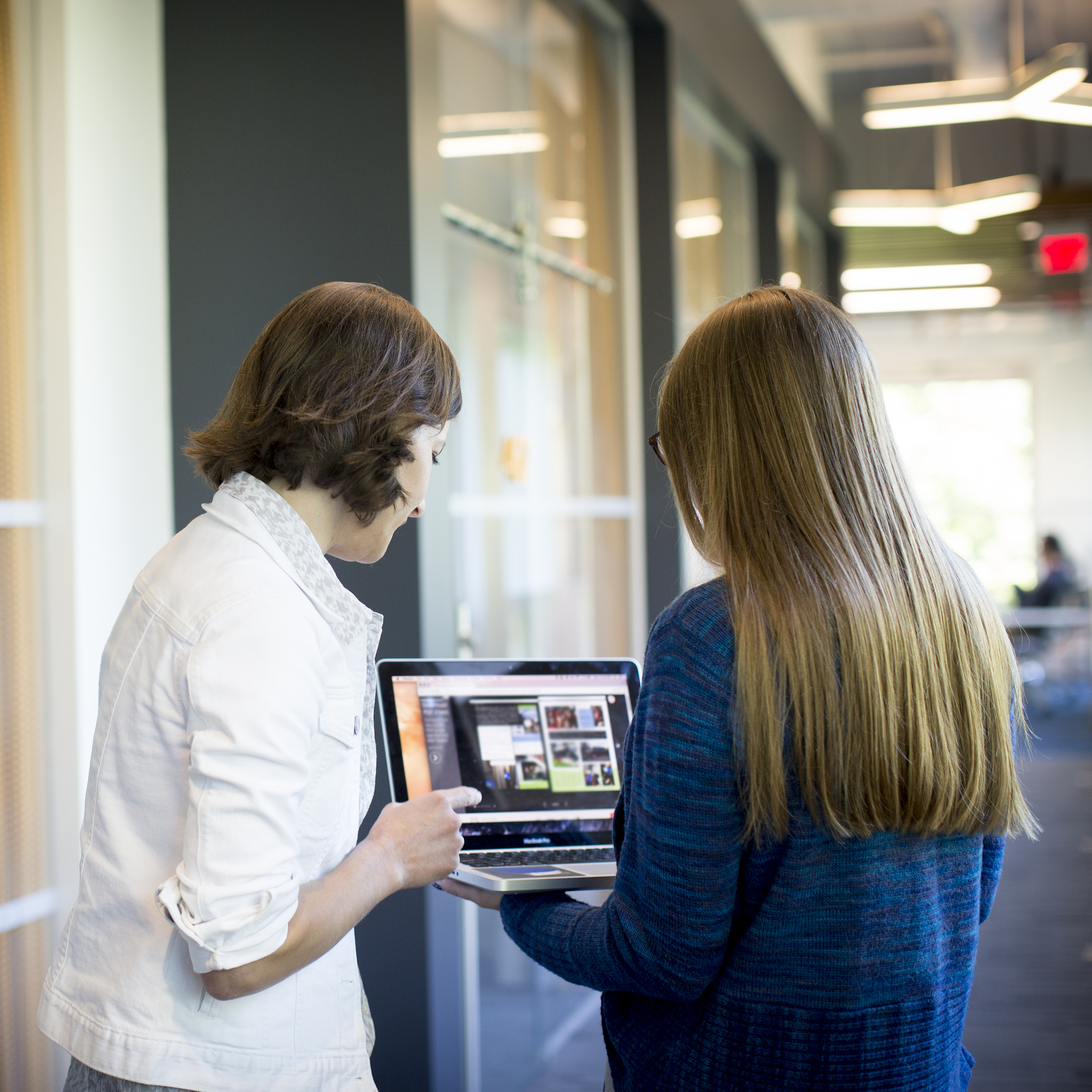 Two people looking at a laptop.