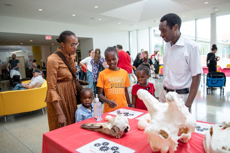 family looking at a display table with bones on it