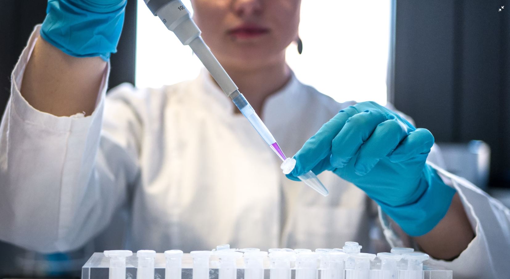 a woman pipettes in a lab