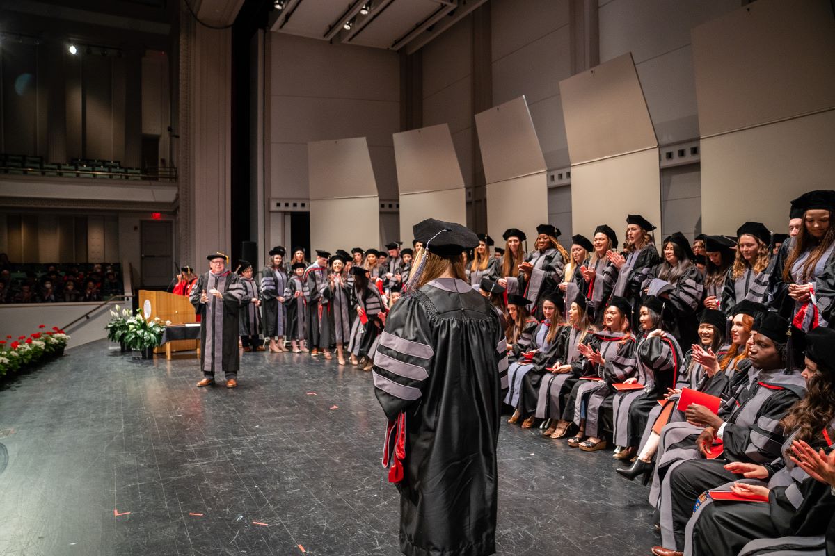 graduate walking on stage to be hooded