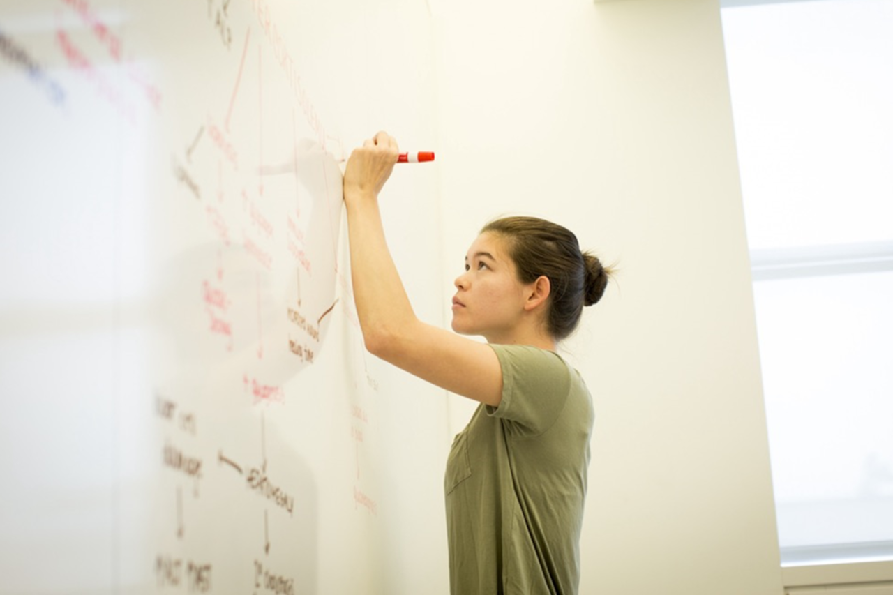 student writing on a whiteboard