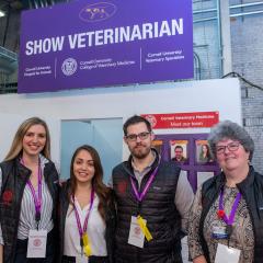 Students and clinicians pose in front of the vet booth