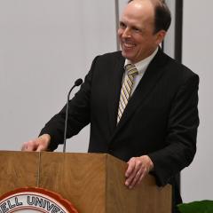 Dr. Cote at podium smiling