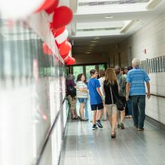 Alumni stand in the CVM hallway with balloons