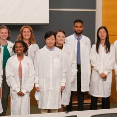 A group of eleven people, students and researchers, are standing in a classroom or lecture hall.