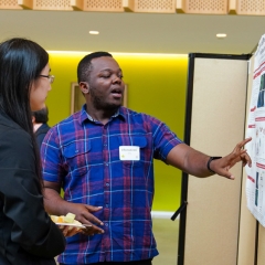 an academic presentation. Two individuals, a young woman and a young man, are the focal point.
