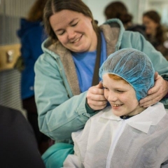 Child trying on protective gown and hat 