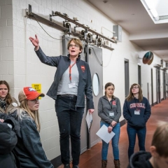 Women speaking to a group in a hallway
