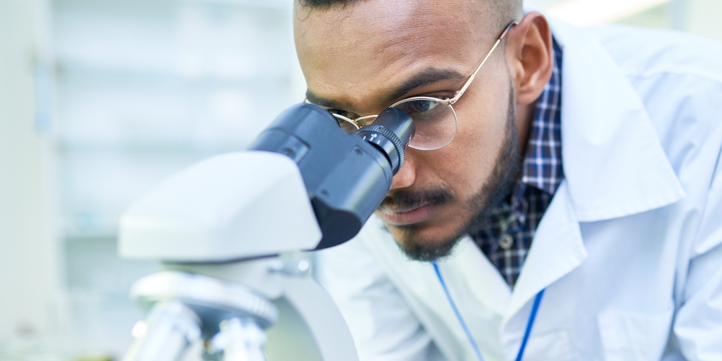 A scientist looking into a microscope