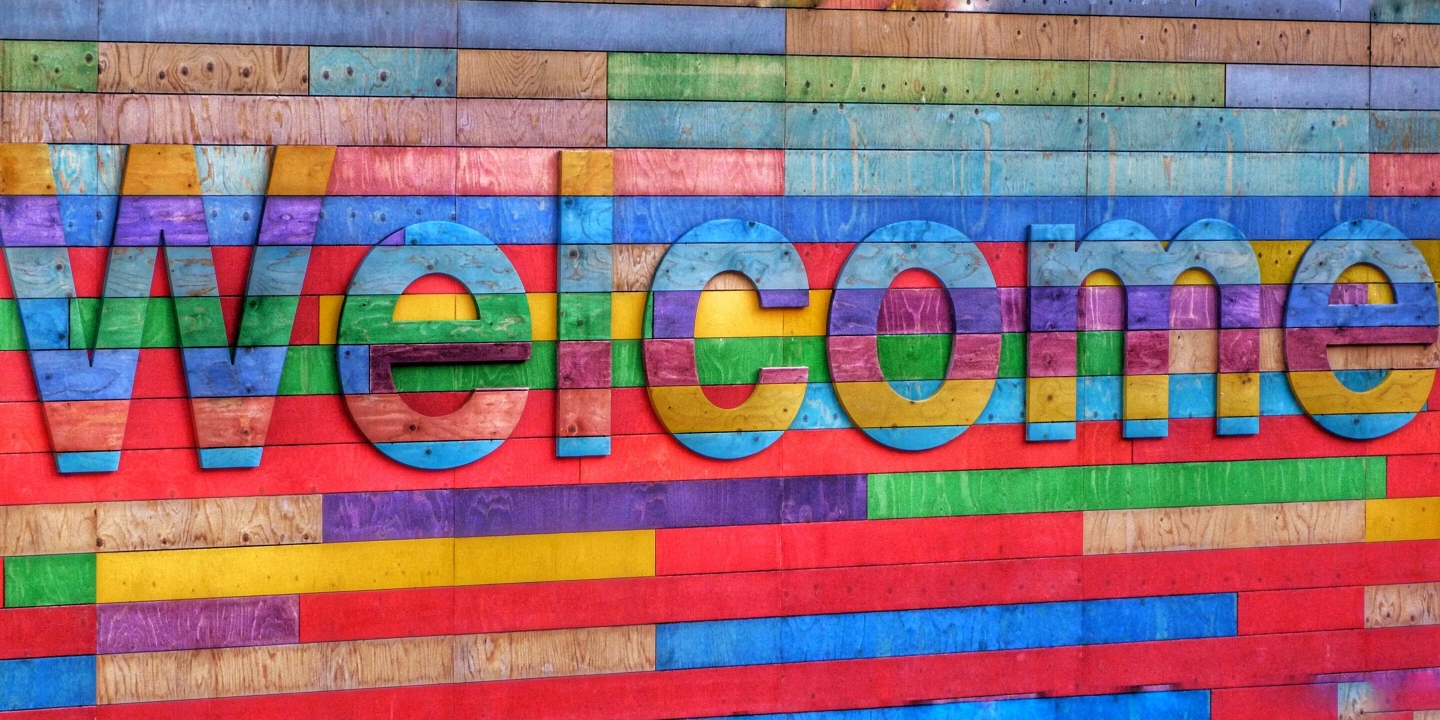 A colorful wood panel with the word welcome