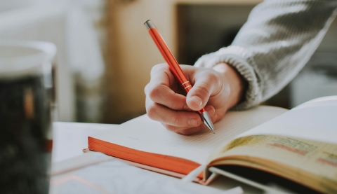 a hand writing in a notebook