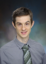 Rafael Kroon Campos wearing a grey dress shirt and green tie.