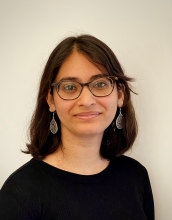 Arunika Das in an off-white background wearing a black shirt.