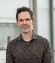 Brian Crane wearing a brown dress shirt with mandala design.