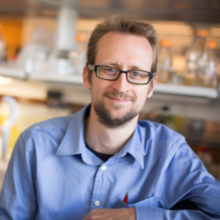 Tobias Doerr in the lab wearing a light blue button up shirt.