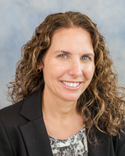 Headshot of woman with wavy brown hair.